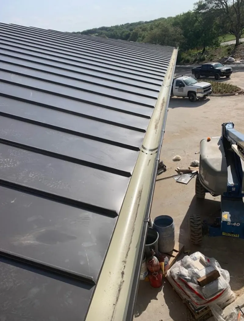 Standing seam panel and gutter detail on a metal roofing jobsite in Niceville